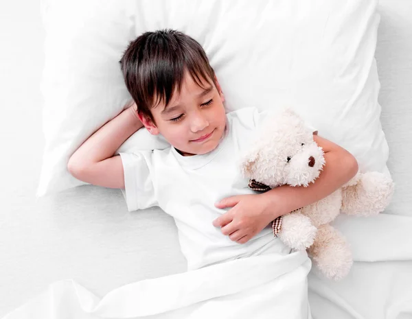 Menino a dormir com ursinho de pelúcia — Fotografia de Stock