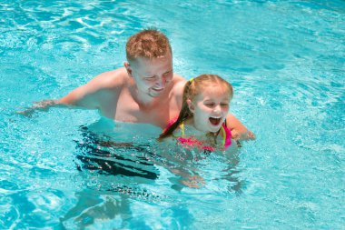 Babası kızının yüzme havuzunda yüzmeyi öğretim