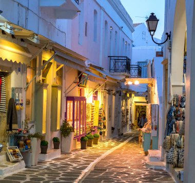Touristic narrow street with souvenirs shops in the evening clipart