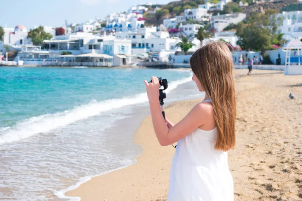 Liten flicka på stranden med Gopro kameran att göra foto — Stockfoto