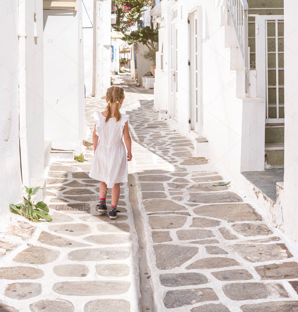 Little girl walking the narrow alley in Greece