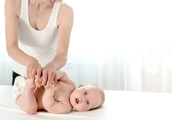 Mother massaging her infant baby — Stock Photo, Image