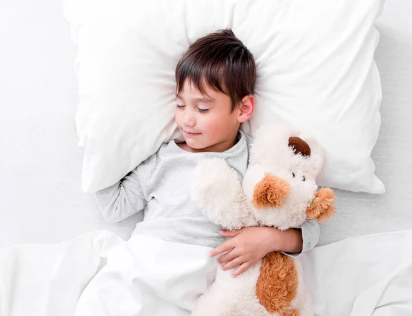 Niño niño sosteniendo peluche juguete mientras duerme —  Fotos de Stock