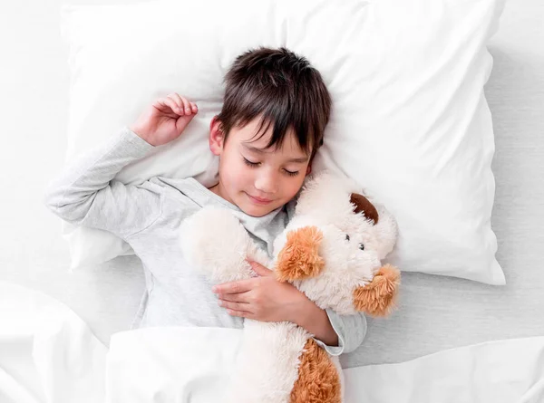 Chłopiec dziecko trzymając pluszowe zabawki podczas snu — Zdjęcie stockowe