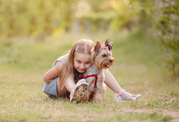 Menina criança com seu pequeno cão terrier Yorkshire no parque — Fotografia de Stock