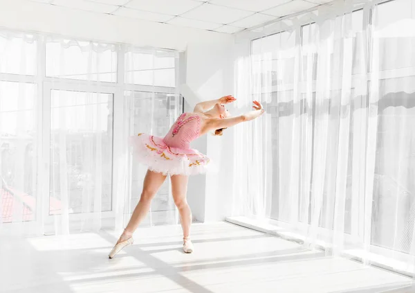 Elegante vrouwelijke balletdanser in roze tutu beoefenen en glimlachen — Stockfoto