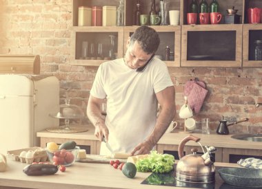 peynir kesme ve telefonda konuşurken çekici adam
