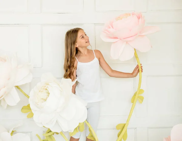 Menina posando em estúdio decoração oposta com flores artificiais — Fotografia de Stock