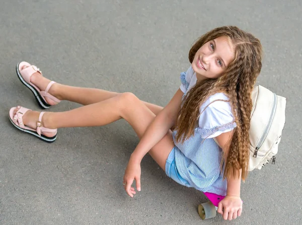 Hosszú haj ül a korcsolyázás lány board — Stock Fotó