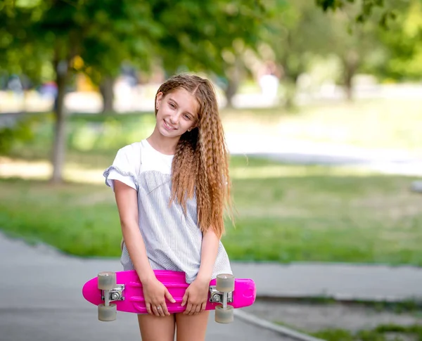 Teenager Mädchen hält ihr rosa Brett — Stockfoto