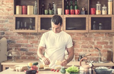 sandviç yapan genç çekici erkek