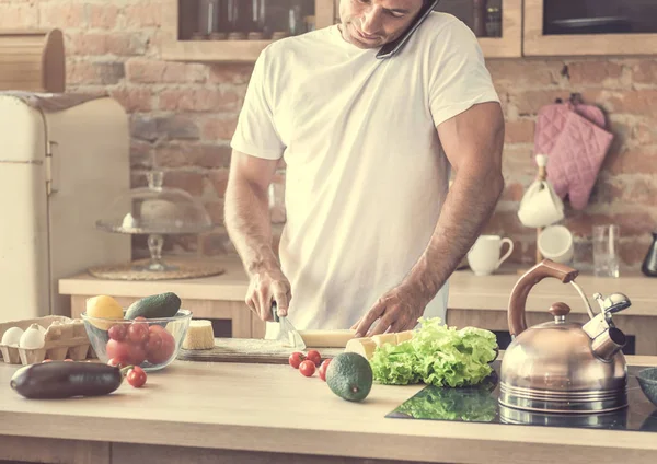 peynir kesme ve telefonda konuşurken çekici adam