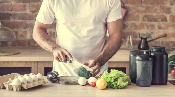 çekici bir genç adam bir avokado keser