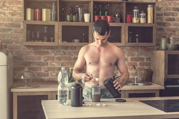 Hombre hace un cóctel de proteínas en la cocina — Foto de Stock