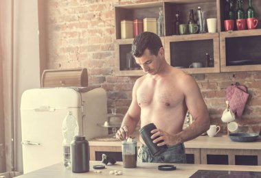 adam bir protein mutfakta kokteyl yapar