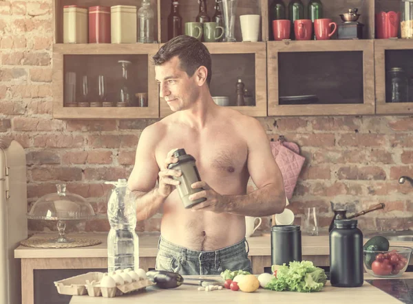 Homme fait un cocktail de protéines dans la cuisine — Photo