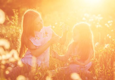 İki küçük kız kardeş çelenk çiçek örgü