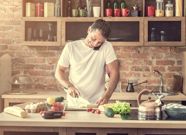 peynir kesme ve telefonda konuşurken çekici adam