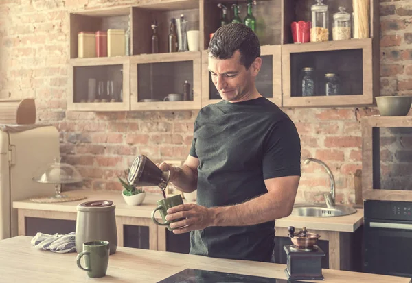 yakışıklı adam taze yapılmış kahve bardak içine dökülen.