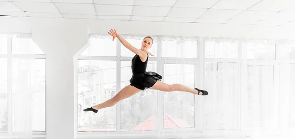 Ballerina danseres uitvoeren van een sprong in witte studio — Stockfoto