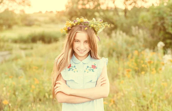 Mignonne petite fille dans une couronne de fleurs — Photo