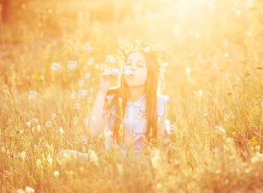 Küçük kız sabun köpüğü üflüyor