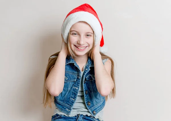 Cute young girl in santa claus hat with crossed arms — Stock Photo, Image