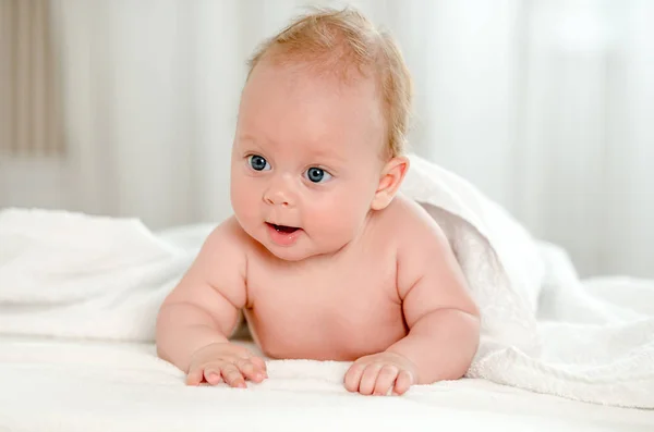 腹の上に横たわる美しい青い目を持つ新生児 ストック画像