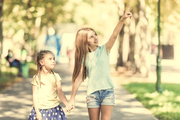 Två små systrar gå i parken — Stockfoto