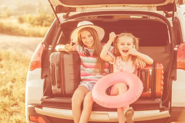 Małe słodkie dziewczyny w bagażniku samochodu z walizki — Zdjęcie stockowe