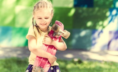 omzuna bir kaykay ile sevimli küçük kız