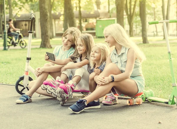 Meninas fazendo selfie ao ar livre enquanto sentado em longboards — Fotografia de Stock