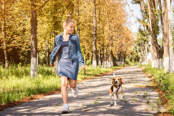 Menina loira andando com cachorrinho bonito — Fotografia de Stock