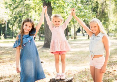 Gülümseyen küçük kızlar Park sevinçle kaldırdı elleriyle ayağa