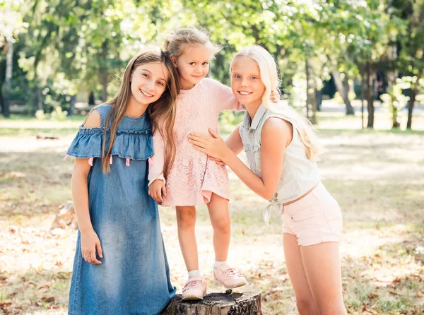 Les petites filles se tiennent câlins dans un parc d'automne ensoleillé — Photo