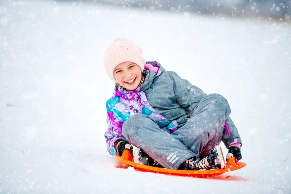 Girl sliding down the hill on saucer sled — Stock Photo, Image