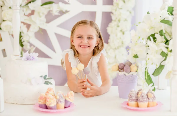 Bambina che tiene colorati lecca-lecca dolci nella barretta di cioccolato — Foto Stock