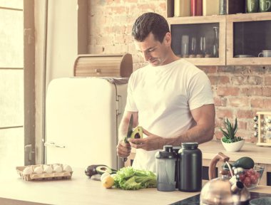 genç çekici adam soyma avokado