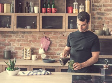yakışıklı adam taze yapılmış kahve bardak içine dökülen.