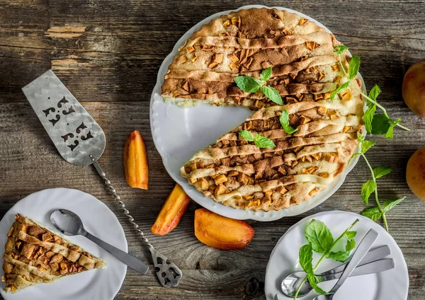 Tarta de melocotón en una vieja mesa de madera — Foto de Stock