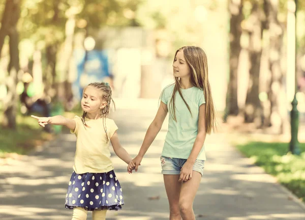 Две маленькие сестры гуляют в парке — стоковое фото