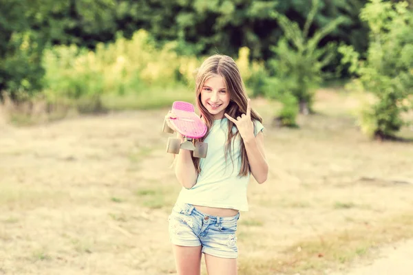 Дівчина-підліток тримає свою рожеву дошку — стокове фото