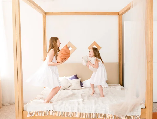 Δύο μικρά κορίτσια αγωνίζονται με μαξιλάρια στο κρεβάτι — Φωτογραφία Αρχείου