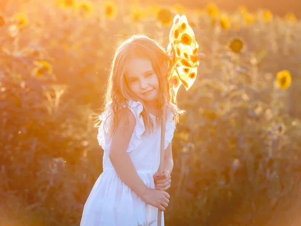 Mignonne petite fille avec un moulin à vent — Photo