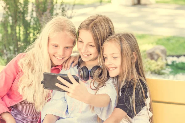 Meisjes maken selfie buitenshuis zittend op longboards — Stockfoto