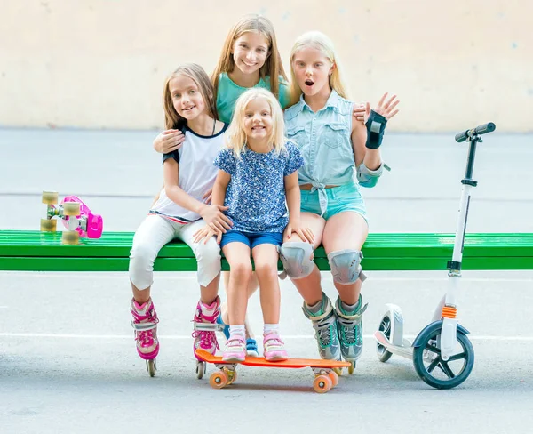 Petites filles souriantes assises sur le banc vert — Photo