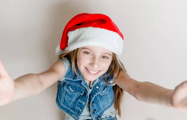 Young little girl makes a selfie in santas hat — Stock Photo, Image