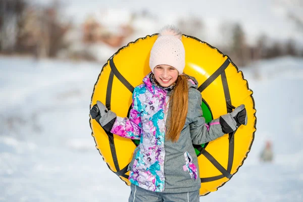 Active girl holding snow tubing
