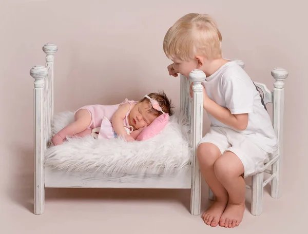 Piccolo ragazzo biondo che guarda sul bambino che dorme — Foto Stock