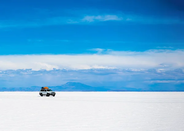 Paisaje soleado de Salar de Uyuni en Bolivia y vehículo todoterreno — Foto de Stock